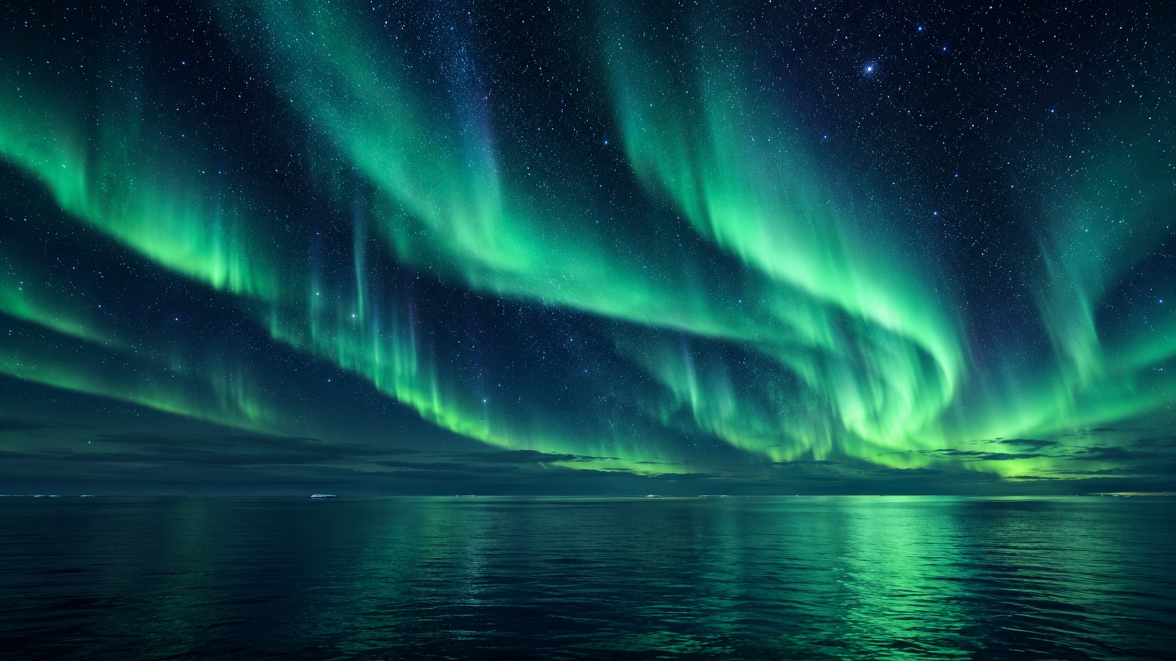 Aurora borealis and stars above open dark Arctic water with a little distant ice